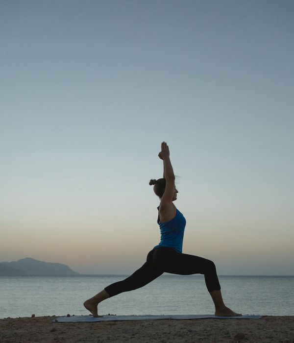 Silhouette of a woman meditating at sunrise, symbolizing energy and peace.
